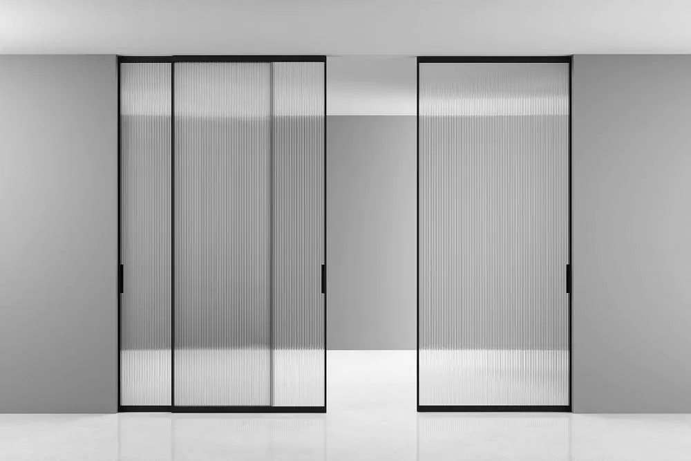 STRATUS–SLIM, translucent Trasparente Sole glass, aluminum canvas frame in Black color. Sliding three–leaf partition in the opening, hidden track in the ceiling.